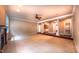 A spacious carpeted living room with a fireplace, ceiling fan, and decorative pillars at 3408 Mount Pisgah Way, Cary, NC 27519