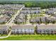 Aerial view of a neighborhood with rows of houses, surrounded by green lawns and winding streets at 364 Skymont Dr, Holly Springs, NC 27540