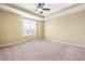 A carpeted bedroom features a ceiling fan and ample natural light from the window at 364 Skymont Dr, Holly Springs, NC 27540