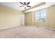 Neutral bedroom featuring a ceiling fan, a window offering natural light and walk in closet at 364 Skymont Dr, Holly Springs, NC 27540