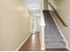 Hallway with wood floors, staircase, white trim, and open doorway at 364 Skymont Dr, Holly Springs, NC 27540