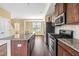 Kitchen with stainless steel appliances, dark wood cabinets, granite countertops, island, and gas range at 364 Skymont Dr, Holly Springs, NC 27540