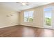 Bright living room with hardwood floors, a ceiling fan, a window, and access to the balcony at 364 Skymont Dr, Holly Springs, NC 27540