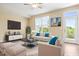 Stylishly staged living room with modern furniture, a large window, and access to the balcony at 364 Skymont Dr, Holly Springs, NC 27540