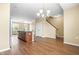 Open-concept living room and kitchen with wood floors, kitchen island, and staircase at 364 Skymont Dr, Holly Springs, NC 27540