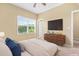 Bedroom boasts a ceiling fan, window with natural light, and modern dresser at 364 Skymont Dr, Holly Springs, NC 27540