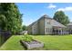 Large backyard with a garden, black fence, and mature trees on a sunny day at 37 Meadow Oaks Cir, Smithfield, NC 27577