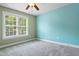 Bright bedroom featuring neutral carpet, a ceiling fan, and a large window providing ample natural light at 37 Meadow Oaks Cir, Smithfield, NC 27577