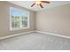 Bedroom showcasing neutral carpet, a ceiling fan, and a large window providing outdoor views at 37 Meadow Oaks Cir, Smithfield, NC 27577