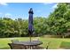 Cozy backyard patio seating area with umbrella and surrounding trees and blue skies at 37 Meadow Oaks Cir, Smithfield, NC 27577