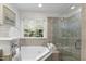 A bright bathroom boasts a soaking tub with tile surround and a glass shower at 3908 Sterling Ridge Ln, Durham, NC 27707