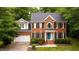 Beautiful two-story brick home featuring a blue front door and well-manicured landscaping at 3908 Sterling Ridge Ln, Durham, NC 27707