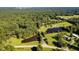 Aerial view of expansive property with mature forest, ponds, outbuildings, and a main residence at 3912 Kildrummy Dr, Durham, NC 27705