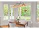 Cozy breakfast nook with views of the backyard through bright windows with wicker lighting at 3912 Kildrummy Dr, Durham, NC 27705