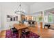 Open dining room with wood table, contemporary light fixture and view to the kitchen at 3912 Kildrummy Dr, Durham, NC 27705