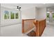 Bright hallway features hardwood railing and light gray carpet at 3912 Kildrummy Dr, Durham, NC 27705
