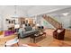 Bright living room with open floor plan, hardwood floors, stairs and neutral colored furniture at 3912 Kildrummy Dr, Durham, NC 27705