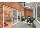 Covered patio with slate floors, brick accent wall, outdoor seating, and views to the home's interior at 3912 Kildrummy Dr, Durham, NC 27705