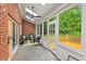 Bright sunroom with slate floors, brick accent wall, lots of windows, and a ceiling fan at 3912 Kildrummy Dr, Durham, NC 27705
