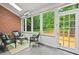 Inviting sunroom with brick accent wall and lots of windows overlooking the landscaped yard at 3912 Kildrummy Dr, Durham, NC 27705