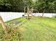 Spacious backyard with a playset and raised garden beds, great for outdoor activities at 407 Elm Farm Pl, Morrisville, NC 27560