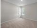Bright bedroom features neutral paint, carpet, a door, and a window at 408 Flagg Rd, Holly Springs, NC 27540