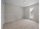 A bright carpeted bedroom features trim, neutral walls, and a window at 408 Flagg Rd, Holly Springs, NC 27540