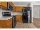 Kitchen featuring wooden cabinets, stainless steel oven, and a modern black refrigerator at 408 Flagg Rd, Holly Springs, NC 27540