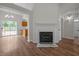 Inviting living room with hardwood floors, fireplace, and view of the kitchen and backyard at 408 Flagg Rd, Holly Springs, NC 27540