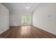 Spacious living room featuring a ceiling fan, large window and hardwood flooring at 408 Flagg Rd, Holly Springs, NC 27540