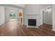 Inviting living room with hardwood floors, fireplace, and view of the kitchen and backyard at 408 Flagg Rd, Holly Springs, NC 27540