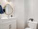 This stylish powder room features a modern vanity and a uniquely shaped wooden-framed mirror at 408 Heritage Village Ln, Apex, NC 27502