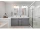 A bathroom features double sinks with gray cabinets, a glass-enclosed shower, and a soaking tub at 408 Heritage Village Ln, Apex, NC 27502