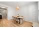 This dining room features a table with seating for four, light wood floors and a woven pendant light at 408 Heritage Village Ln, Apex, NC 27502