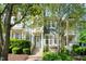 Inviting two-story townhome with a charming front porch, lush greenery, and a well-manicured lawn at 408 Heritage Village Ln, Apex, NC 27502