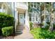 Inviting two-story townhome with a charming front porch, lush greenery, and a well-manicured lawn at 408 Heritage Village Ln, Apex, NC 27502