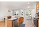 A stylish kitchen features stainless appliances, wood cabinets and a dining area bathed in sunlight at 408 Heritage Village Ln, Apex, NC 27502