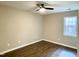 This bedroom features wood floors, a ceiling fan, and a window for natural light at 411 Gooseneck Dr # A1, Cary, NC 27513