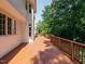 Wide wooden deck on the side of a home with a mix of brick and white siding at 4204 Thetford Rd, Durham, NC 27707