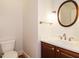 Bathroom featuring a sink with vanity, toilet, mirror and lighting fixture at 4204 Thetford Rd, Durham, NC 27707