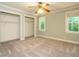 Bedroom featuring neutral paint, carpet, two large closets with open doors, and one window at 4204 Thetford Rd, Durham, NC 27707