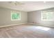 Spacious bedroom with ample natural light from two large windows and neutral carpet at 4204 Thetford Rd, Durham, NC 27707