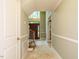 Long hallway featuring tile flooring, white trim, and access to the entryway and staircase at 4204 Thetford Rd, Durham, NC 27707