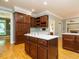 The kitchen features a central island with cooktop and wood cabinetry at 4204 Thetford Rd, Durham, NC 27707