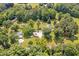Expansive aerial view of a home nestled among lush green trees and surrounding landscapes at 4702 Pleasant Green Rd, Durham, NC 27705