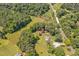 Aerial view of a property surrounded by trees and featuring a red roofed building and a nearby creek at 4702 Pleasant Green Rd, Durham, NC 27705