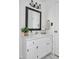 Bright bathroom features a white vanity, decorative mirror, and marble-look tile flooring at 4702 Pleasant Green Rd, Durham, NC 27705