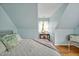 Comfortable bedroom featuring a dormer window, light blue walls, and hardwood flooring at 4702 Pleasant Green Rd, Durham, NC 27705