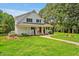 Beautiful two-story home with white siding, black shutters, a welcoming porch, and a green lawn at 4702 Pleasant Green Rd, Durham, NC 27705