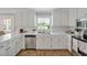 Well-lit kitchen featuring white cabinets, stainless steel appliances, and a view from the window at 4702 Pleasant Green Rd, Durham, NC 27705